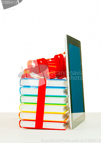 Image of Books tied up with ribbon and tablet PC against white background