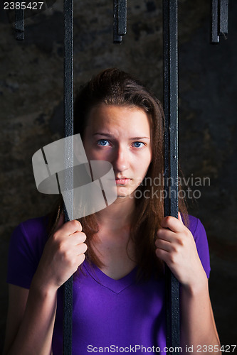 Image of Young woman behind the bars