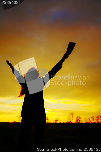 Image of Woman staying with raised hands