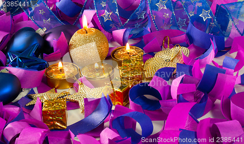 Image of Christmas decorations and candles over blue background