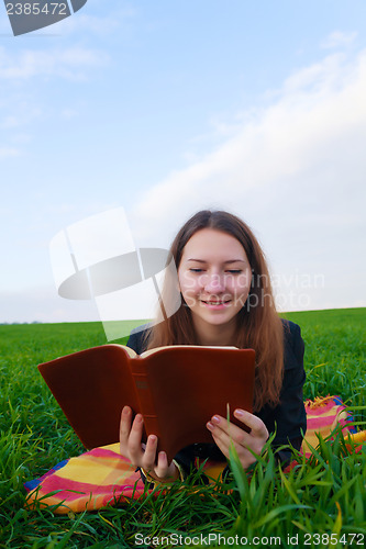 Image of Teen girl reading the Bible outdoors