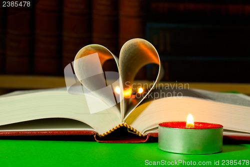 Image of Open book with burning candle