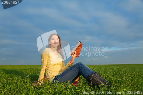 Image of Teen girl reading the Bible outdoors