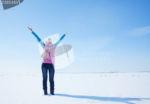 Image of Teen girl staying with raised hands