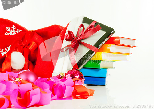 Image of Electronic book reader with stack of books in bag against white background