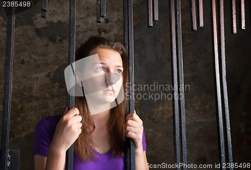 Image of Young woman behind the bars