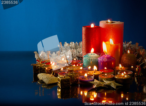 Image of A lot of burning colorful candles against dark blue background