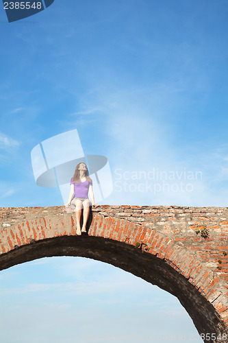 Image of Young woman sitting outdoors