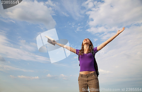 Image of Young woman staying with raised hands