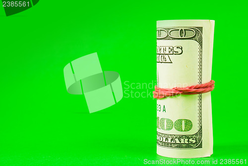 Image of Roll of US dollars tied up with rubber
