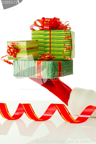 Image of Santa's hand holding Christmas presents against white background