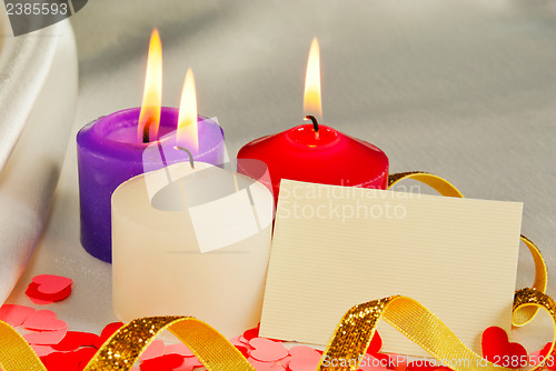 Image of Three burning candles over light background