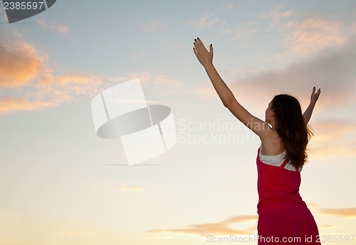 Image of Woman staying with raised hands