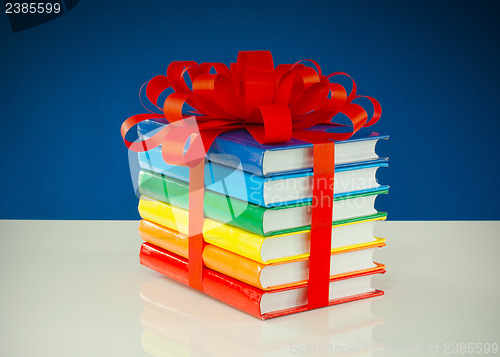 Image of Stack of colorful books tied up with red ribbon