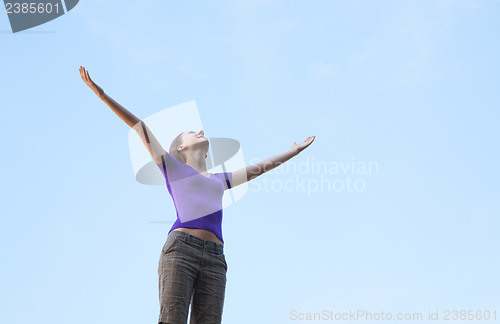 Image of Young woman sitting with raised hand