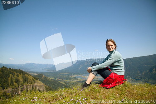 Image of Woman sits at the top of a cliff