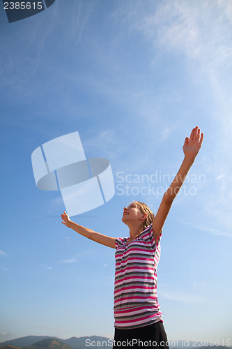 Image of Teenage girl staying with raised hands