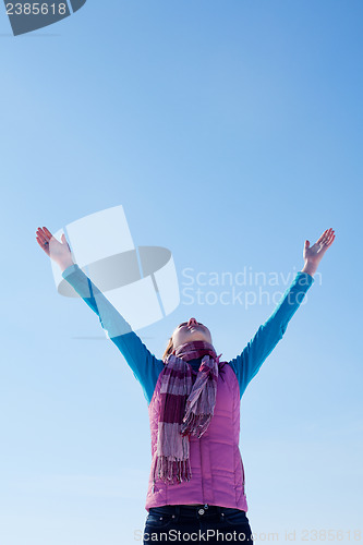 Image of Teen girl staying with raised hands