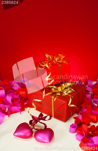 Image of Valentine's day presents and hearts over red background