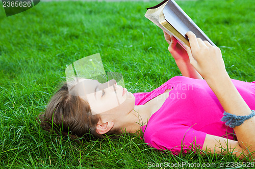 Image of Teen girl reading the Bible outdoors