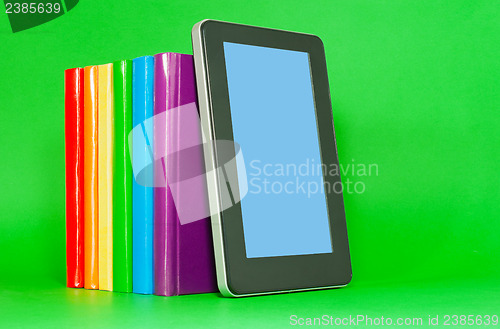 Image of Row of colorful books and tablet PC