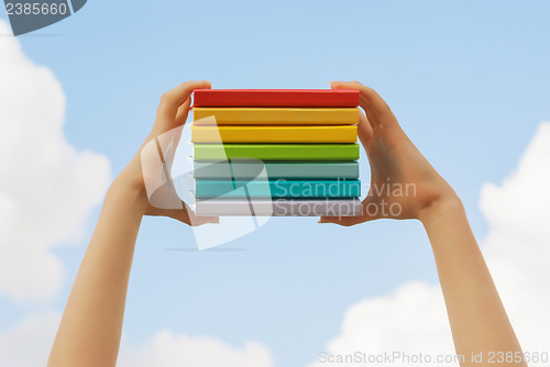 Image of Hands holding colorful hard cover books