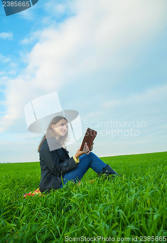 Image of Teen girl reading the Bible outdoors