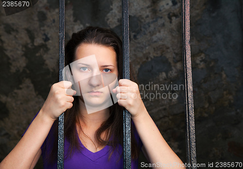 Image of Young woman behind the bars