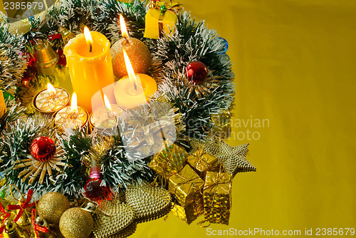 Image of Christmas garland and burning candles over golden background