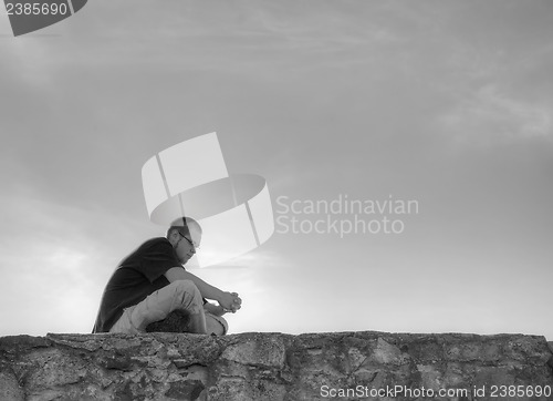 Image of Young man sittting outdoors