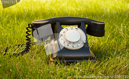 Image of Retro styled rotary telephone on grass