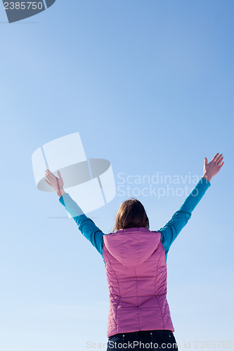 Image of Teen girl staying with raised hands