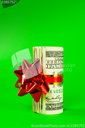 Image of A wad of US one hundred dollar bills tied up with red ribbon