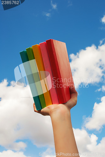 Image of Hands holding colorful hard cover books