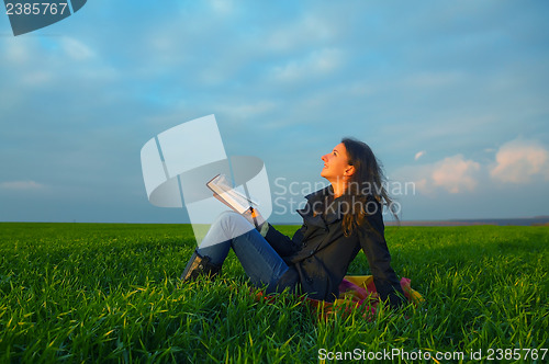 Image of Teen girl reading the Bible outdoors