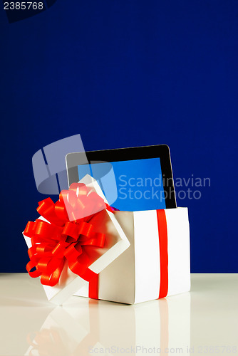 Image of Tablet PC in a gift box against blue background