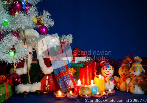 Image of Three snowmen in front of the Christmas presents and burning can