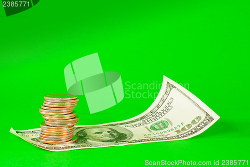 Image of Coins stacked in bars laying on stack of 100 dollar bill