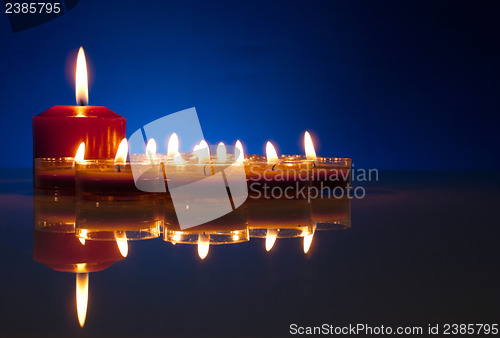 Image of A lot of burning candles against dark blue background