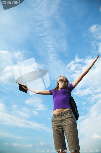 Image of Young woman staying with raised hands