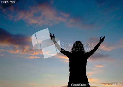 Image of Woman staying with raised hands