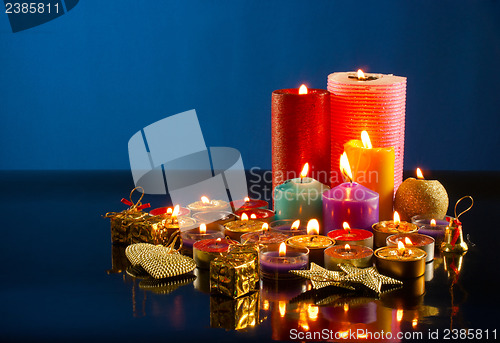 Image of A lot of burning colorful candles against dark blue background