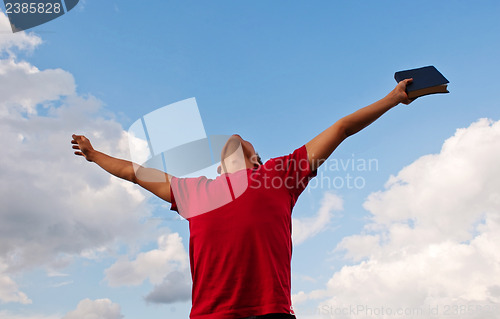 Image of Young man staying with raised hands