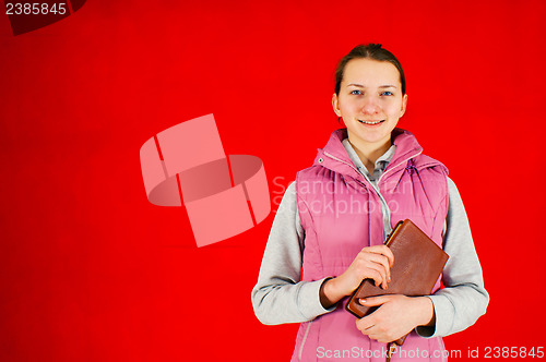 Image of Teen girl staying with a book