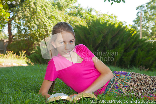 Image of Teen girl reading the Bible outdoors