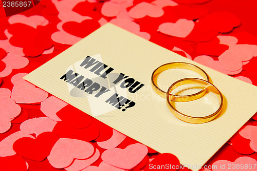 Image of Two rings and a card with marriage proposal