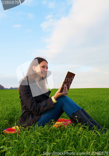 Image of Teen girl reading the Bible outdoors