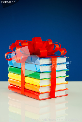 Image of Stack of colorful books tied up with red ribbon