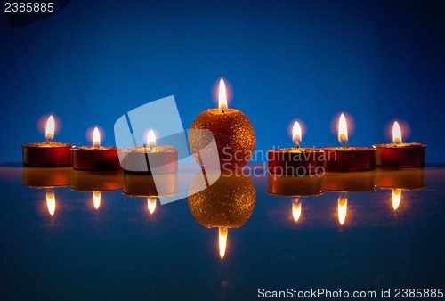 Image of Seven burning candles over blue background