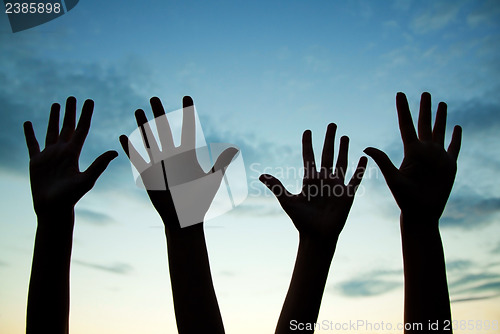 Image of Four raised hands 